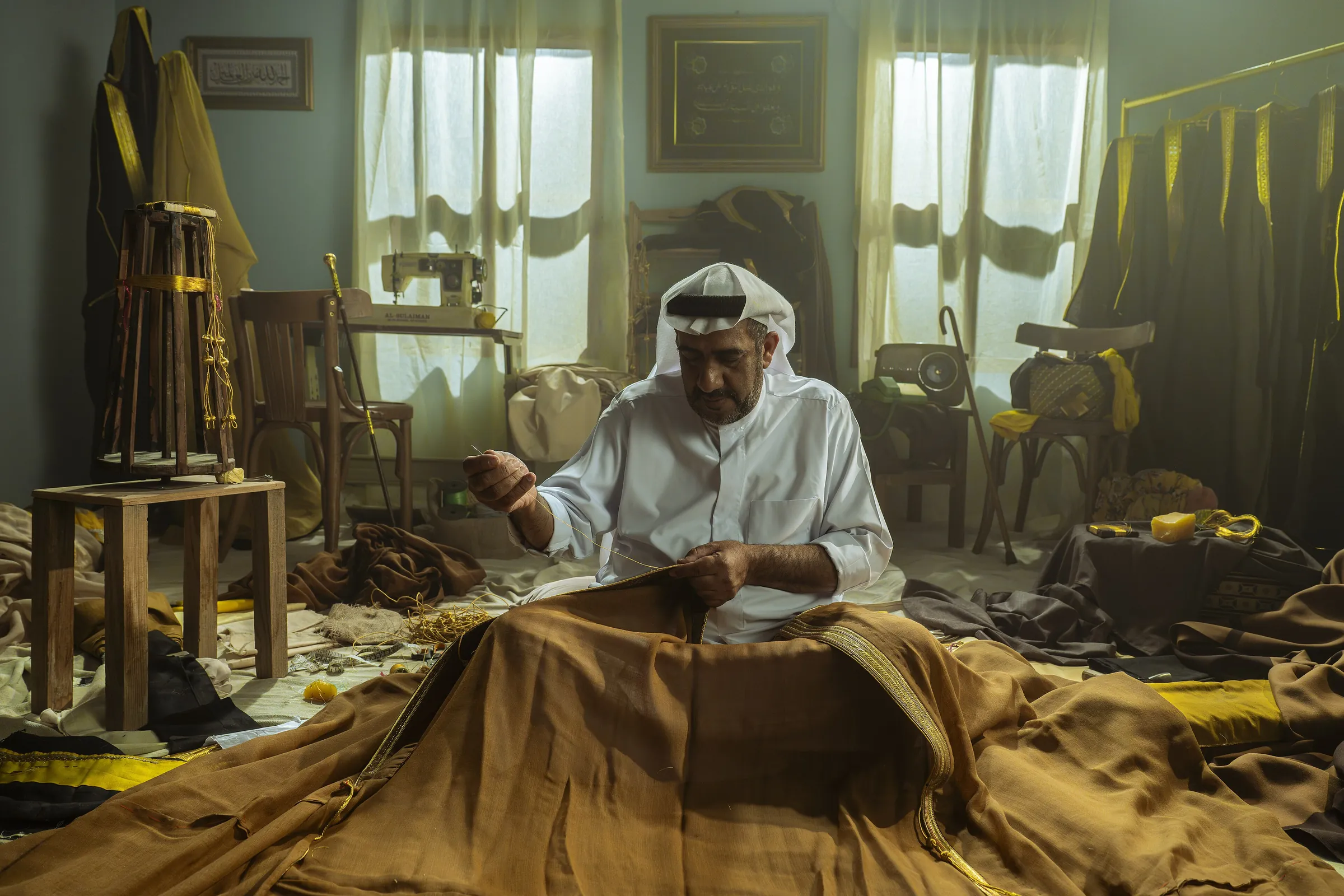 حرفي من الأحساء يخيط المشلح الحساوي يدويًا في ورشته